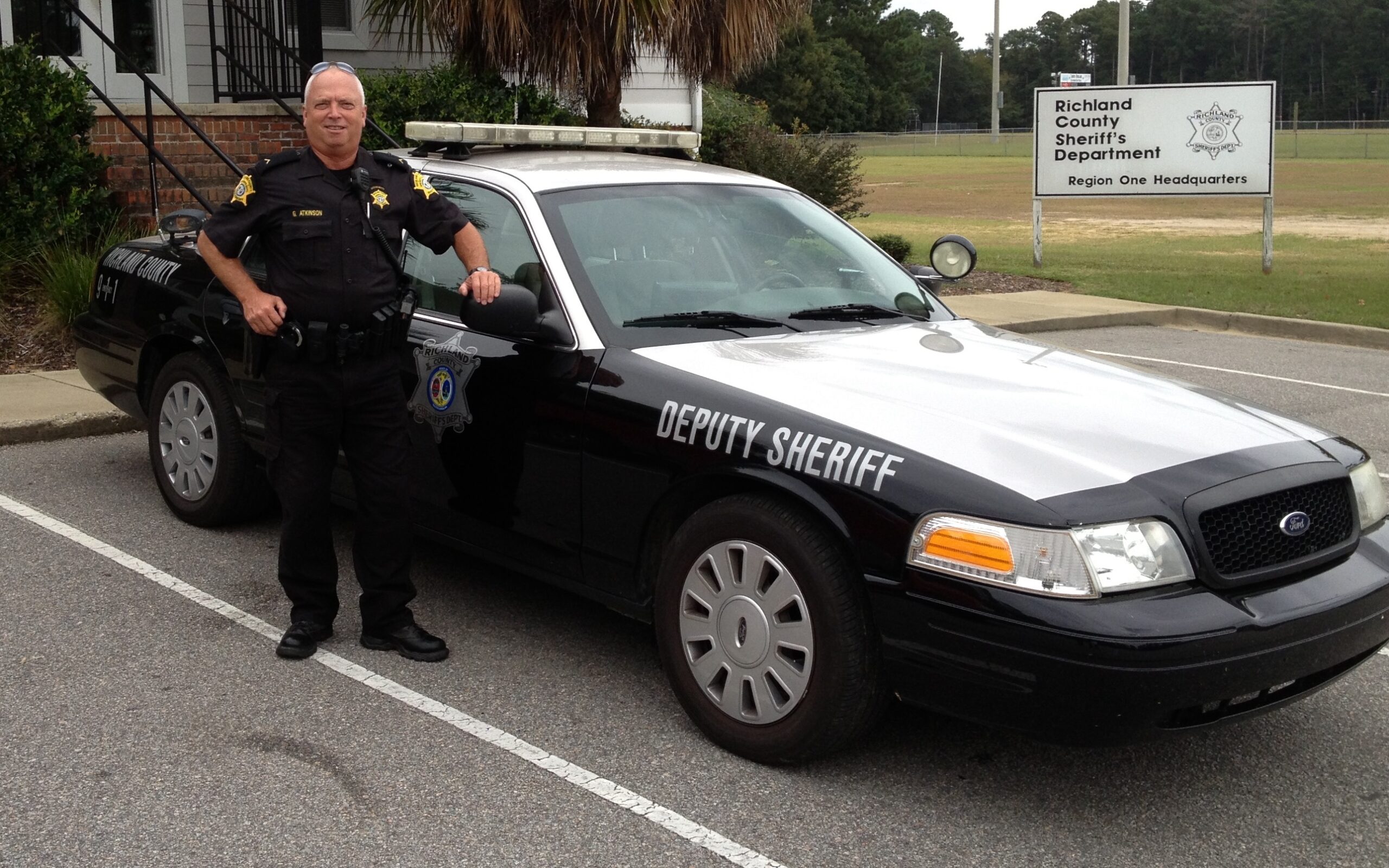 Reserve Deputy standing beside patrol car